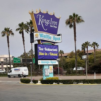 Large sign in front of the Kings Inn in San Diego, California. It is purple and shaped like a crown at the top.